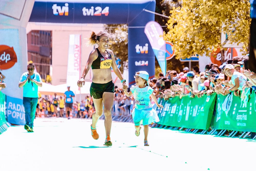 Woman finishing marathon with daughter
