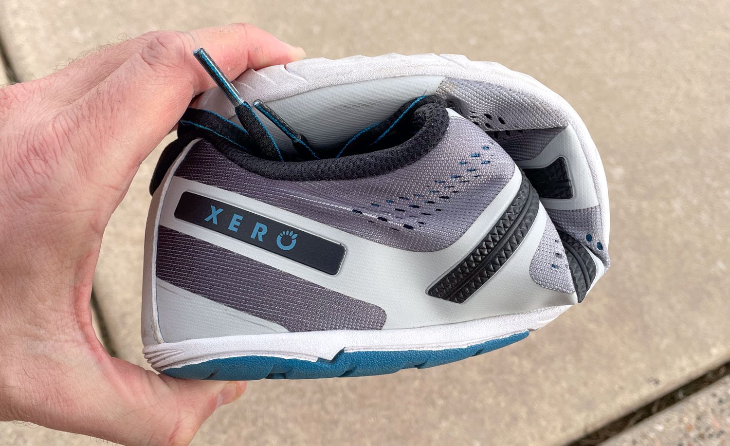 Hand holding a barefoot style shoe folded in half